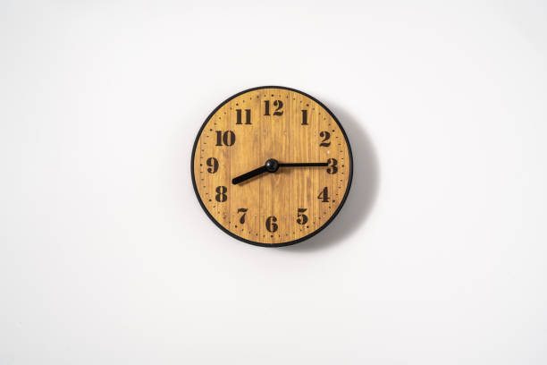 istock wood office wall clock with white dial on white background. wall clock on white background, top view. 1293308615