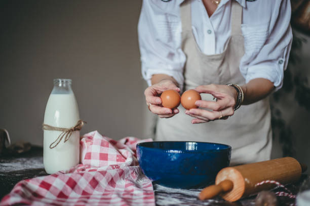 istock Woman in The Kitchen Giving Recipes, Using Milk, Eggs And Flour For Making Cake 1293311821