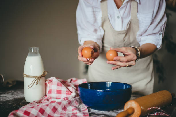 istock Woman in The Kitchen Giving Recipes, Using Milk, Eggs And Flour For Making Cake 1293311901