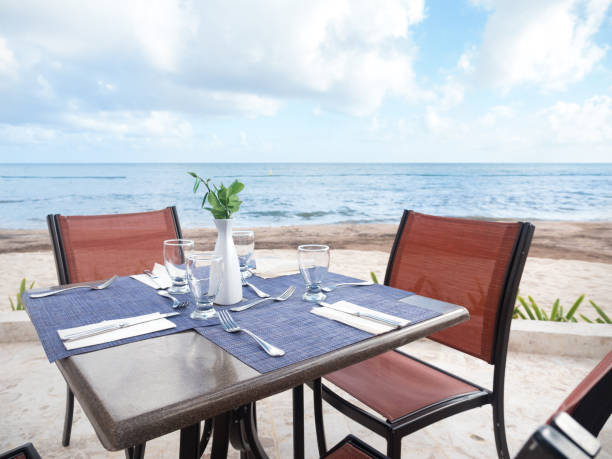 istock Table with dinner setting at outdoors restaurant near tropical sea 1293312116