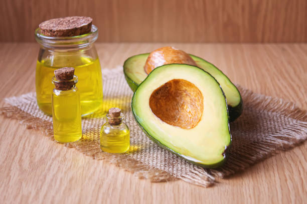 istock Avocado and avocado oil on wooden background. Selective focus 1293315677