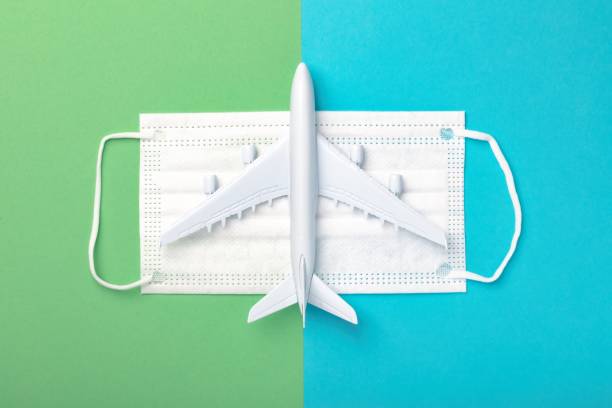 istock Plane model and face mask on blue and green background with copy space. International flights after concept of coronavirus (COVID-19). 1293317851