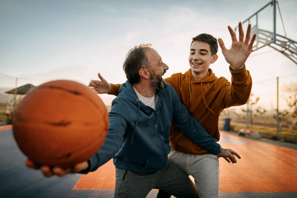 отец играет в баскетбол со своим сыном - basketball sport men basketball player стоковые фото и изображения