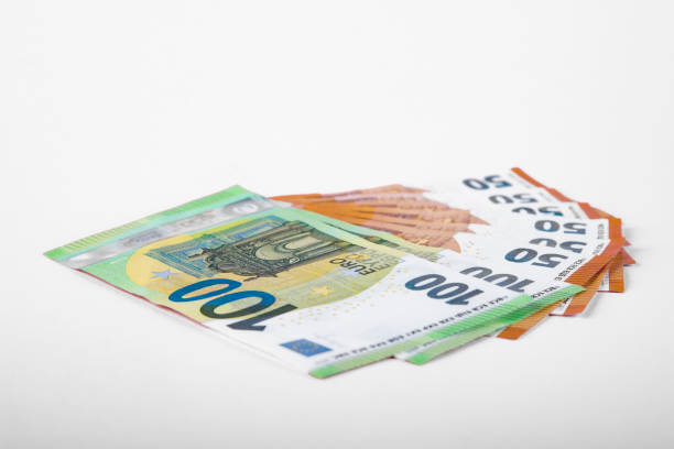 istock 100 and 50 Euro bank notes in a row on pink background 1293318219