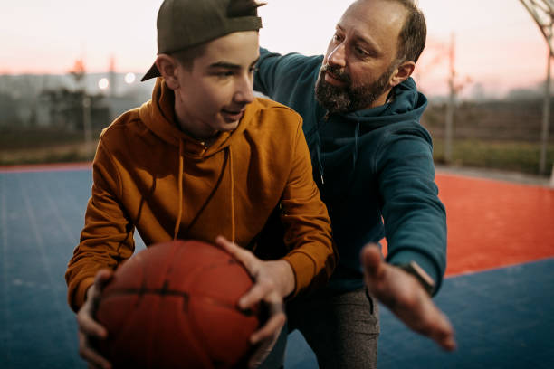 istock Father playing basketball with his son 1293320129