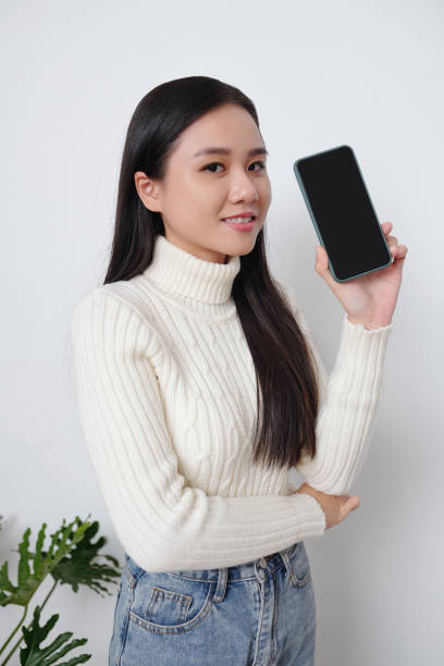 istock Young woman showing smartphone 1293320827
