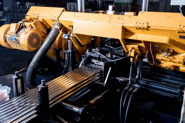 istock Automatic band saw machine with water coolant cutting metal pipes. 1293323229