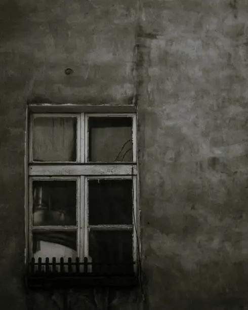The only, black and white, lonely and old window on entire wall
