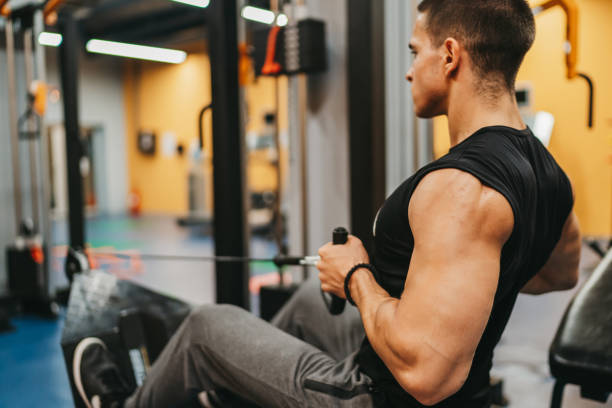 istock Young man doing rowing exercises at the gym 1293327535