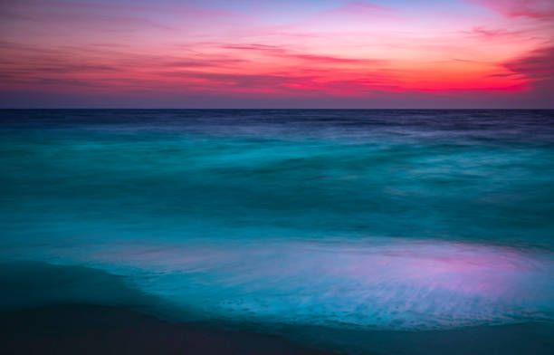istock Vibrant Sunset Seascape over Turquoise Colored Sea Waves in Winter on Cape Cod 1293327720