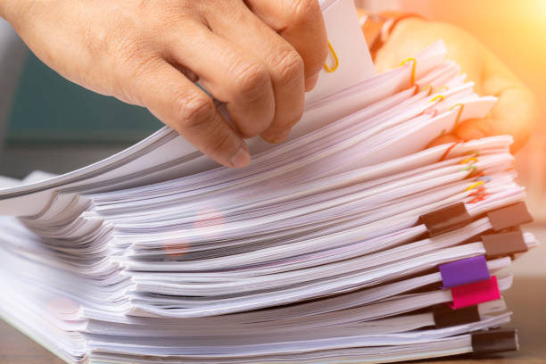 istock Business man hand pick up Stack overload document report paper with colorful paperclip, business and paperless concept. 1293327944