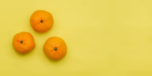 istock Ripe tangerine isolated on a yellow background with copy space. Top view, flat lay 1293330954