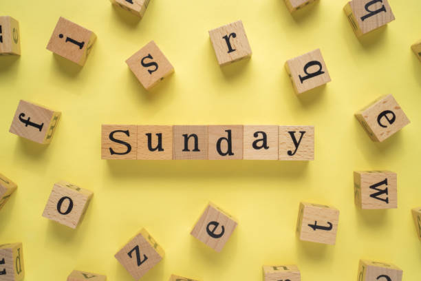 istock Text SUNDAY on wooden cubes with yellow background 1293331137