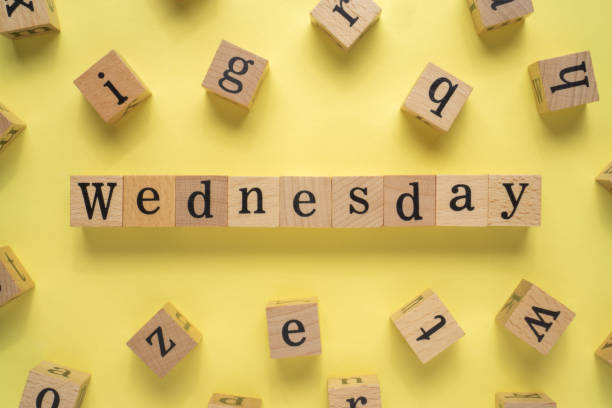 istock Text WEDNESDAY on wooden cubes with yellow background 1293331143