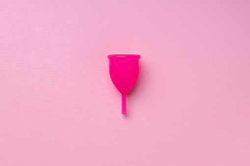 Copa menstrual sobre la vista superior de fondo rosa photo