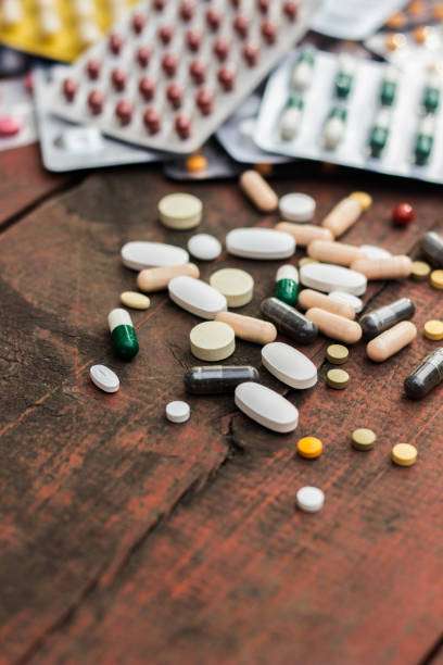 Medications and tablets on a wooden texture table stock photo