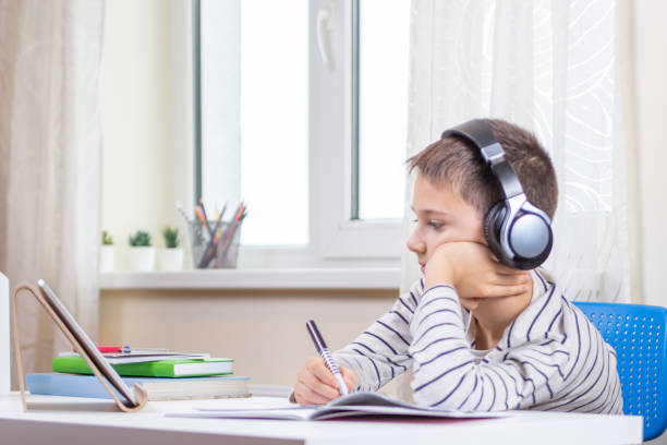 istock Online learning, remote education at home. Kid with digital tablet computer having online lesson, making homework 1293335780