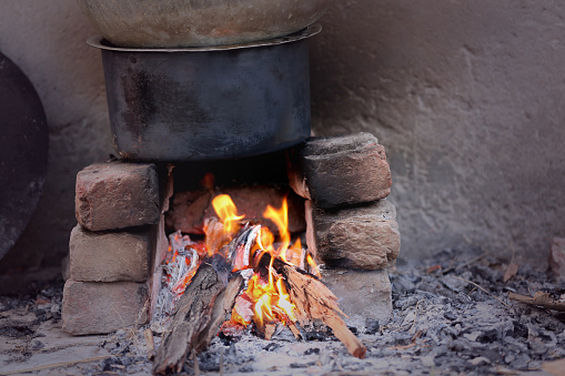 Cooking food on hearth during day time.