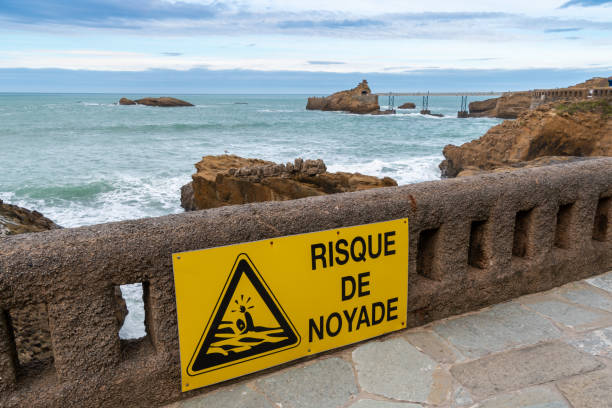 znak drogowy na skraju oceanu atlantyckiego, ostrzeżenie o "ryzyku utonięcia" napisane w języku francuskim - waters edge nature water wave zdjęcia i obrazy z banku zdjęć