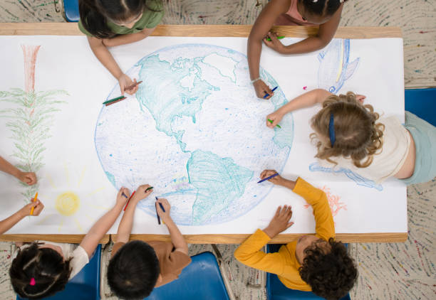 istock Kindergarten children doing a giant doodle of the globe 1293346730