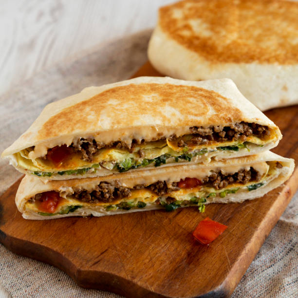 istock Tasty Homemade Beef Crunchwrap Quesadilla on a rustic wooden board, side view. 1293354509