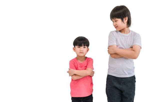 short child boy in red t shirt and tall child boy in white t shirt standing arms crossed and looking face isolated on white background. big and small kid concept at be friends. - fashion fashion model asian ethnicity tall imagens e fotografias de stock