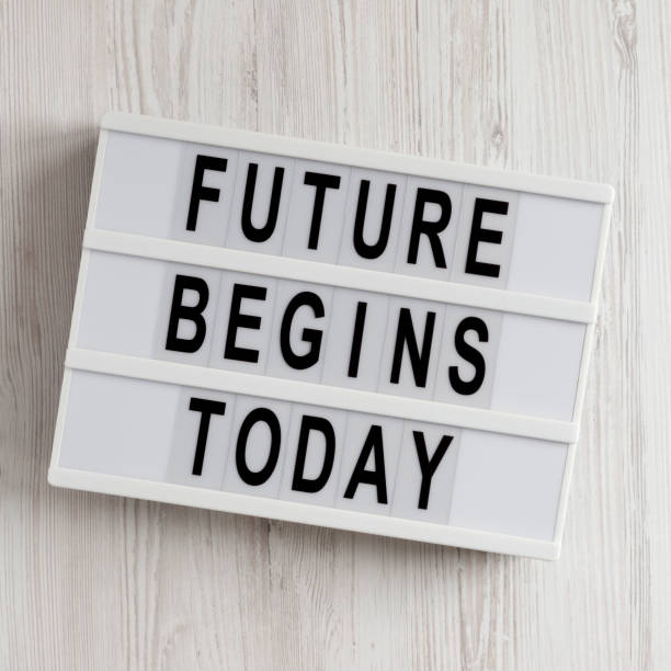 istock 'Future begins today' words on a lightbox on a white wooden background, top view. Overhead, from above, flat lay. 1293358607