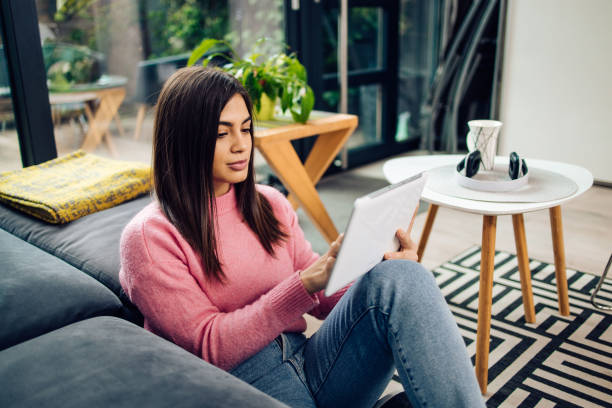istock Beautiful woman using tablet at home 1293360180
