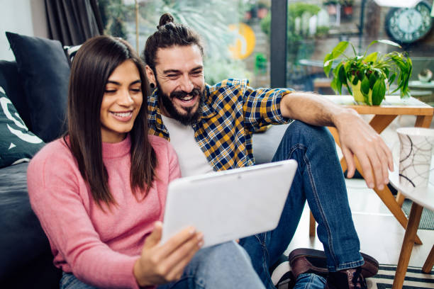 istock Young happy couple watching something online and having fun at home 1293360210