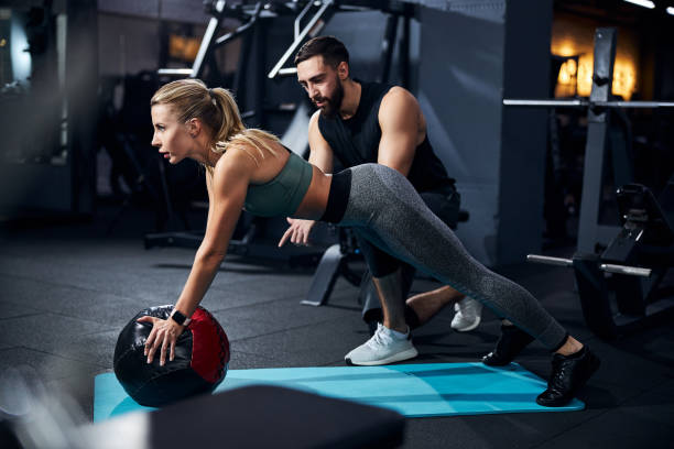 istock Young woman doing exercises while using the ball in the gym 1293366052