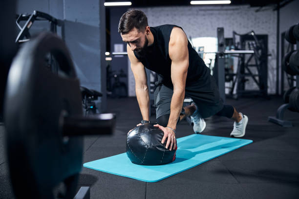 istock Serious male keeping a body plank with a stuffed ball 1293366054