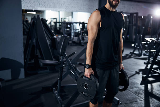 istock Young male person carrying two disk weights 1293366072