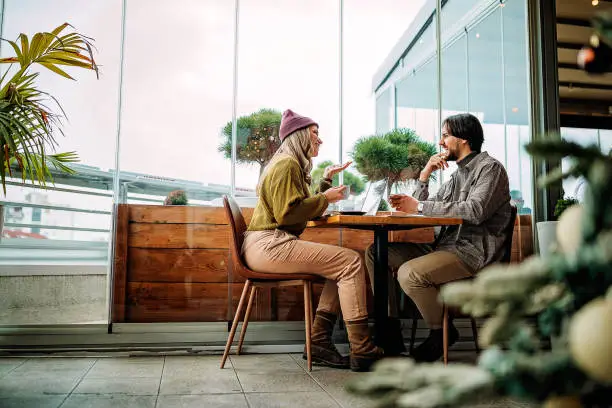 Young couple doing freelance work in cafe