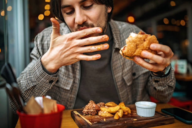 hamburger delizioso - man eating foto e immagini stock