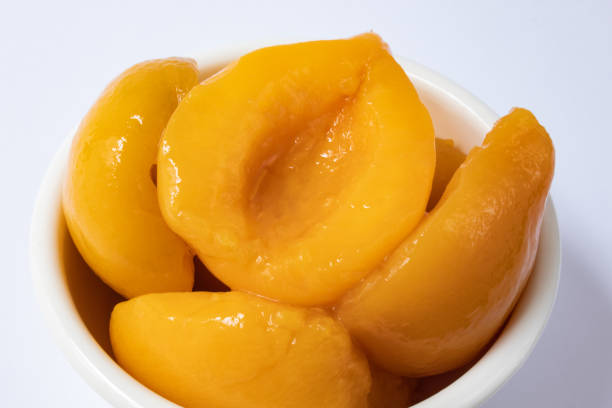 istock Halved peaches in syrup in white bowl 1293369478