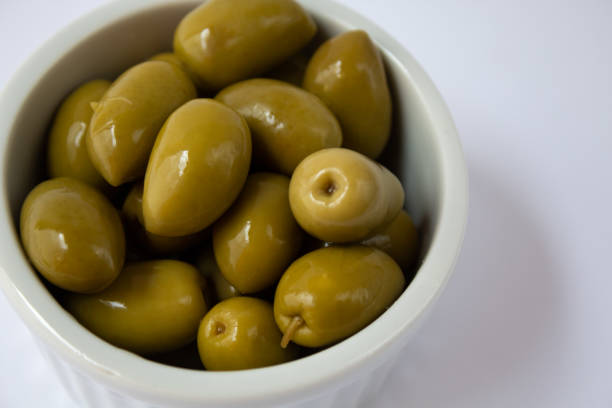istock Pickled green olives in white bowl on white background 1293369513