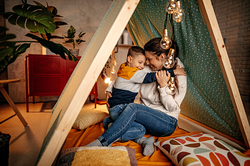 Mother and son relaxing in a tent in the living room