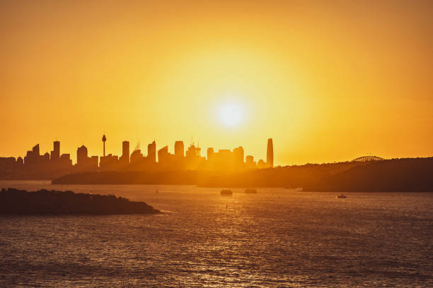 beau coucher de soleil de soirée tiré du port de sydney avec l’horizon de sydney à l’arrière-plan, vu de fairfax lookout au sanctuaire de north head. tourné en décembre 2020. bateaux naviguant dans le port. - passenger ship flash photos et images de collection