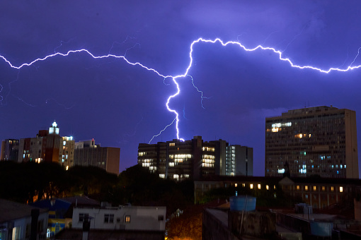 Lightning on background of night sky. Weather and climate. Flash of lightning. Natural disaster. Dark dramatic sky. Storm