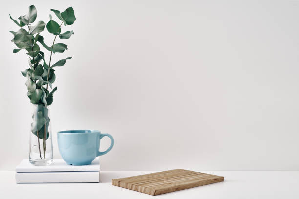 istock A mug, a stack of books, a wooden board and a transparent vase with eucalyptus branches. Eco-friendly materials in interior decor, minimalism. Copy space, mock up 1293373086