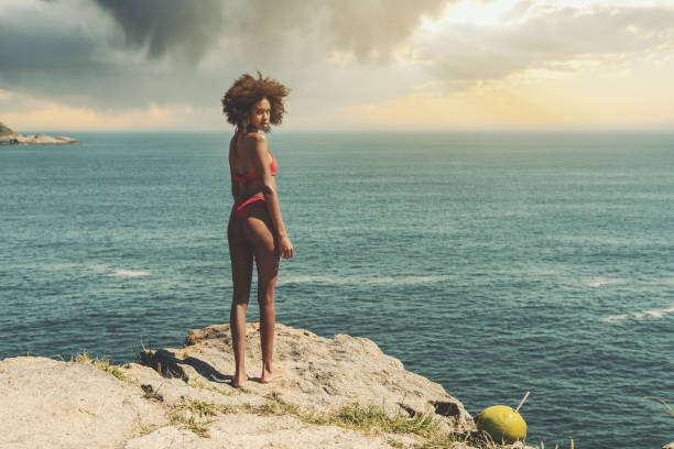 istock Black cute girl on an ocean cliff 1293375422