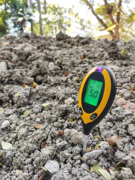 Photo of Testing soil pH acidity and alkali property. newly fill soil dump has a little acid property. digital measure instrument for scientific gardening and farming.