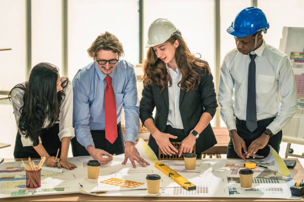 istock architecture and engineering business background of architect and engineer project development team brainstorming and working together with project floor plan on table in architect office 1293391521