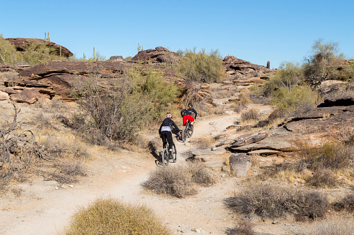 December 20, 2020 - Phoenix, Arizona, USA: Two bikers traverse the Hidden Valley Trail in the desert foothills above Phoenix, Arizona.  Nearby is a natural tunnel formed by falling rocks that can be accessed along the trail.