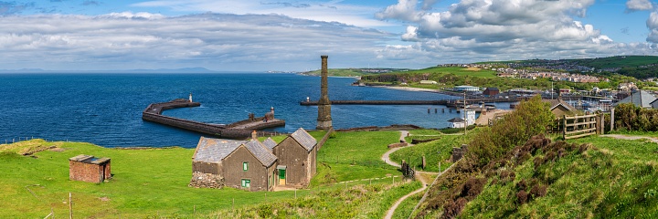 Whitehaven, Cumbria, England, UK - May 03, 2019: View over Whitehaven, the Candlestick Chimney, the piers, the lighthouses and Bransty in the background