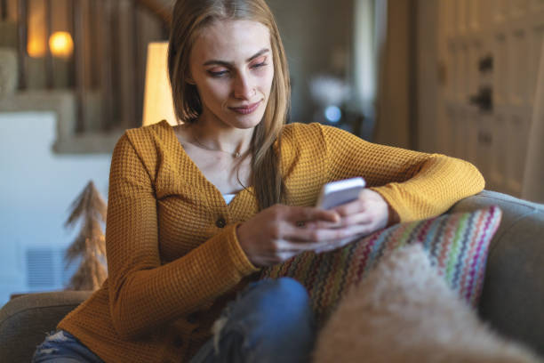 istock Generation Z Female Using Smart Phone at Home on the Couch 1293395380