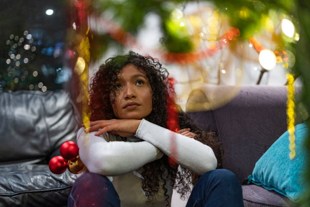 istock Bored woman at home while looking at christmas tree 1293398757