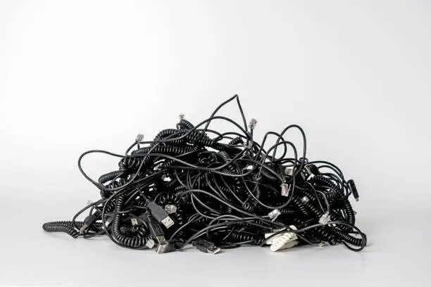 Photo of Heap of different computer cables and plugs with a moden digital tablet isolated on white background