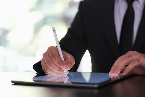 Businessman Signing Digital Contract On Tablet Using Stylus Pen