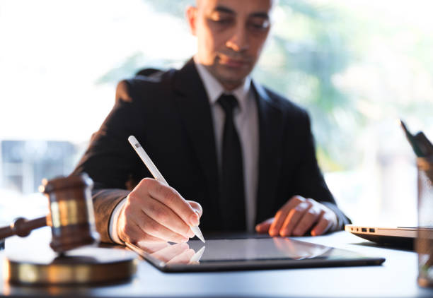 Businessman Signing Electronic Legal Document On Digital Tablet Businessman Signing Electronic Legal Document On Digital Tablet lawyer stock pictures, royalty-free photos & images